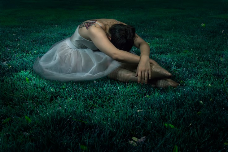 Dancer woman sitting on night grass scene